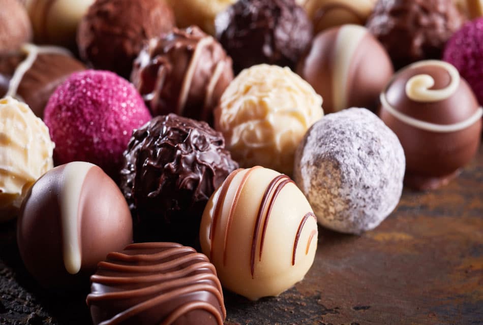 Assorted round truffle chocolates on a marble table