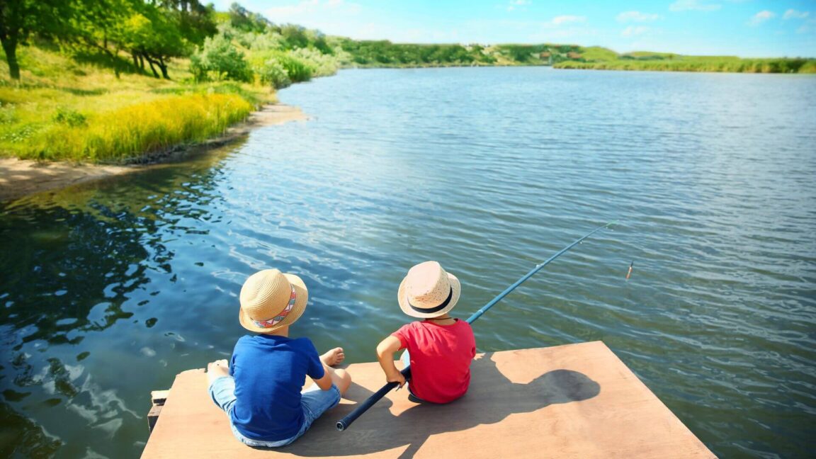 two young boys fishing on docks of great lake