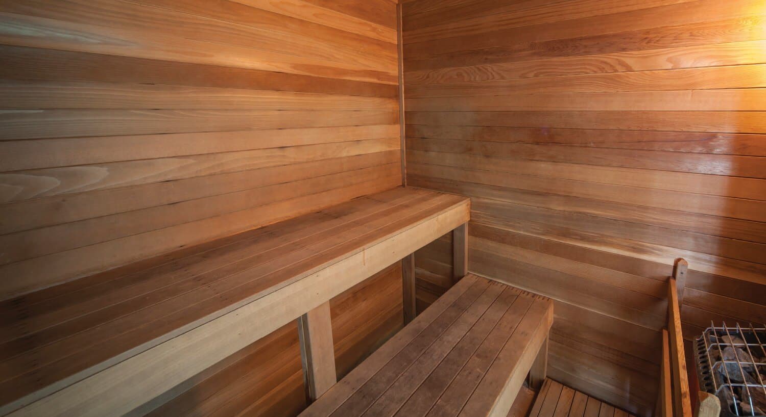 Interior of a sauna with wood walls and two bench seats