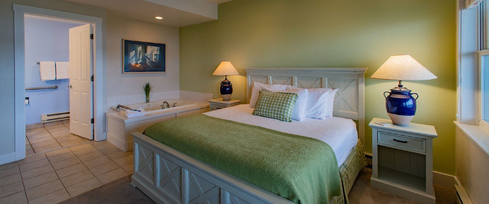 Bedroom with queen bed, jacuzzi tub and doorway into a bathroom