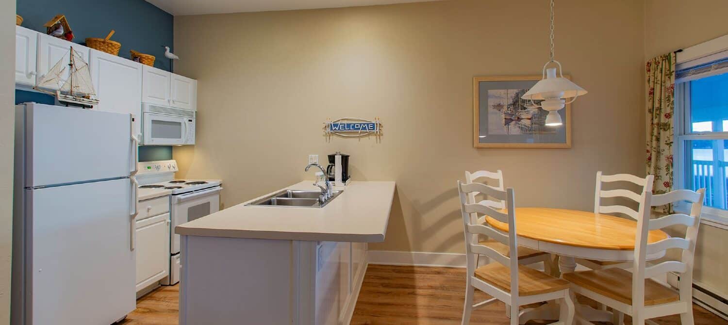 White kitchen with hardwood floors and table with four chairs