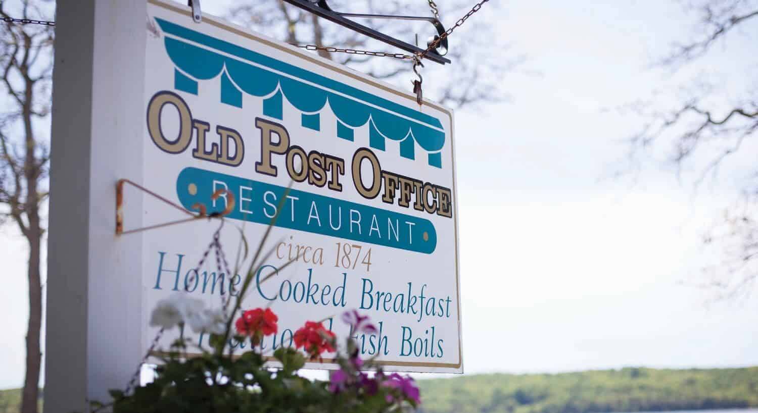 White and blue business sign for a restaurant built in 1875, marketing home cooked breakfast